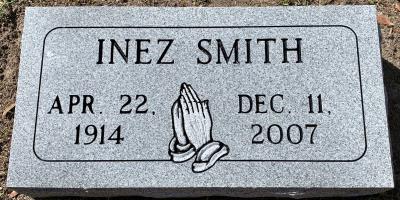 individual gray granite headstone with praying hands and a rounded corner panel design
